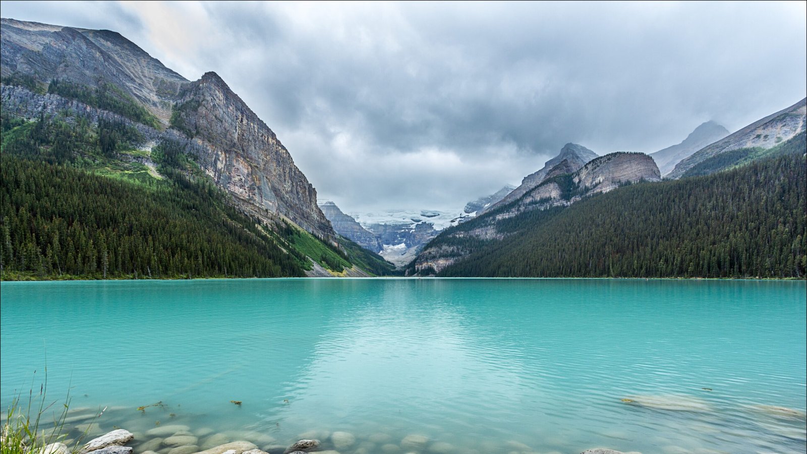Turquoise waters of Lake Louise surrounded by snow-capped peaks